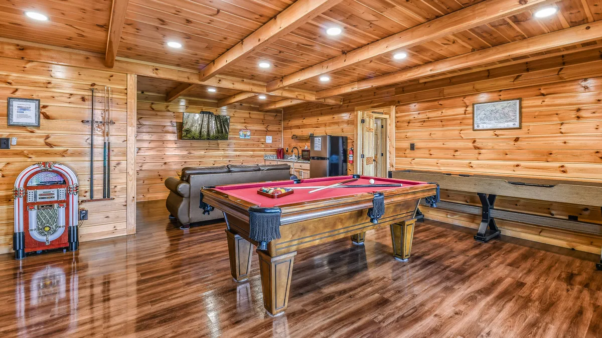 This interior shot highlights a lively game room with a pool table, jukebox, and sofa—an ideal spot for friendly competition and shared laughter after a day out.
