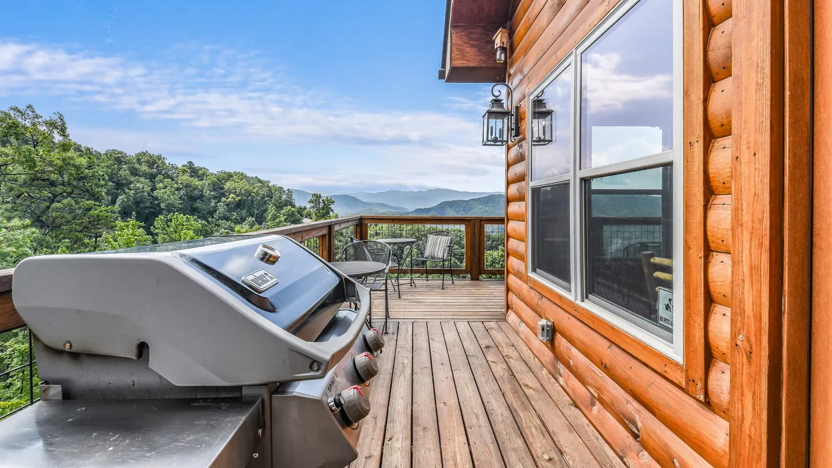 This image focuses on the grill area set on the wooden deck, complete with comfortable furniture and unobstructed mountain views. It hints at lively outdoor meals, barbecues, and gatherings with friends or family.